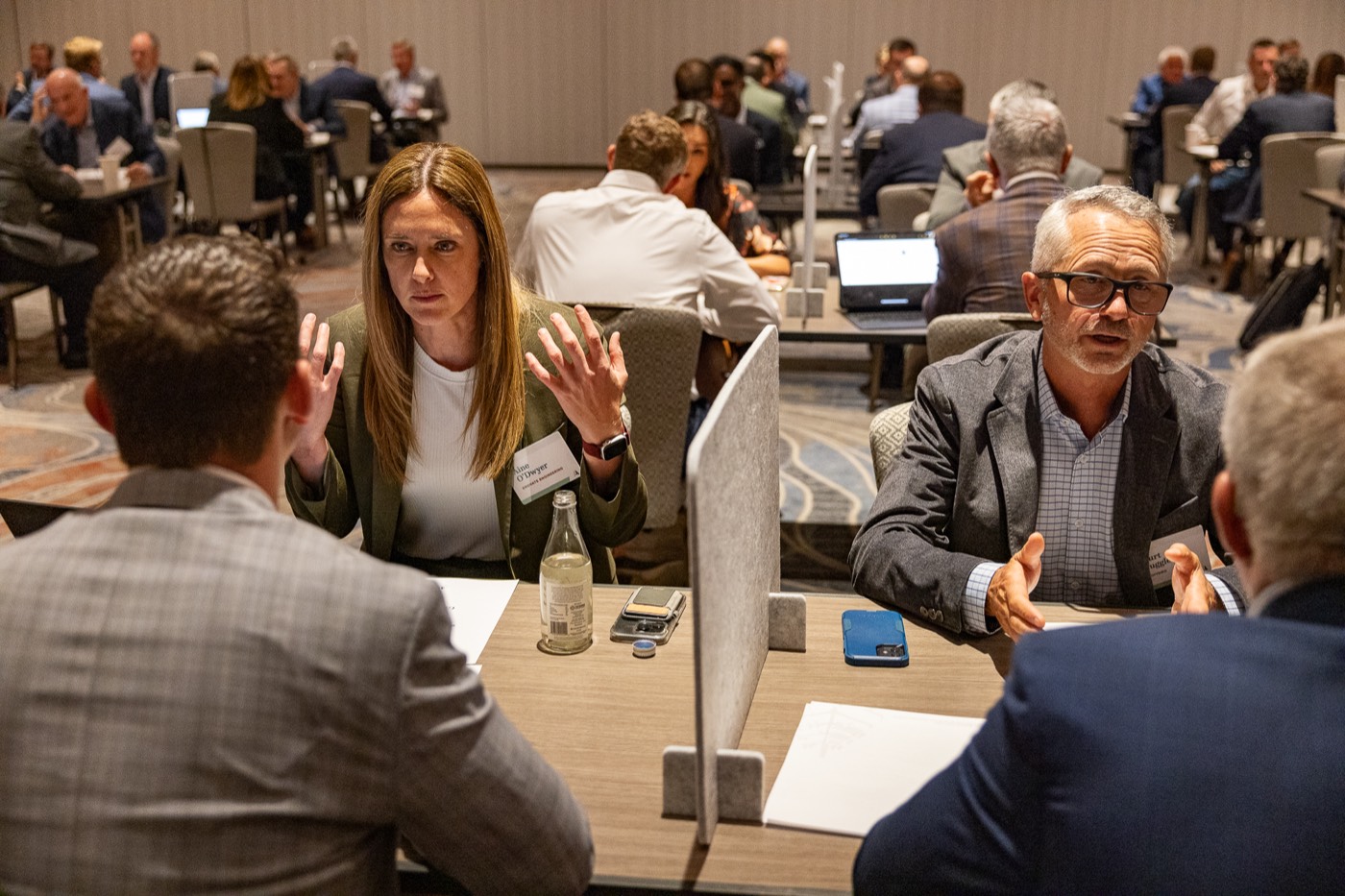 Attendees talking in pairs across round tables during lightning meetings