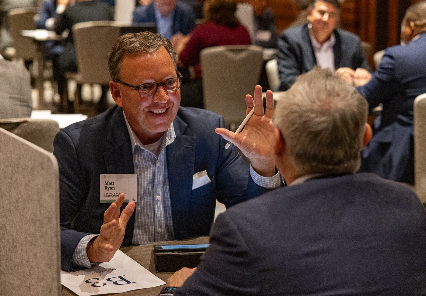 Two attendees in conversation at a lightning meeting table